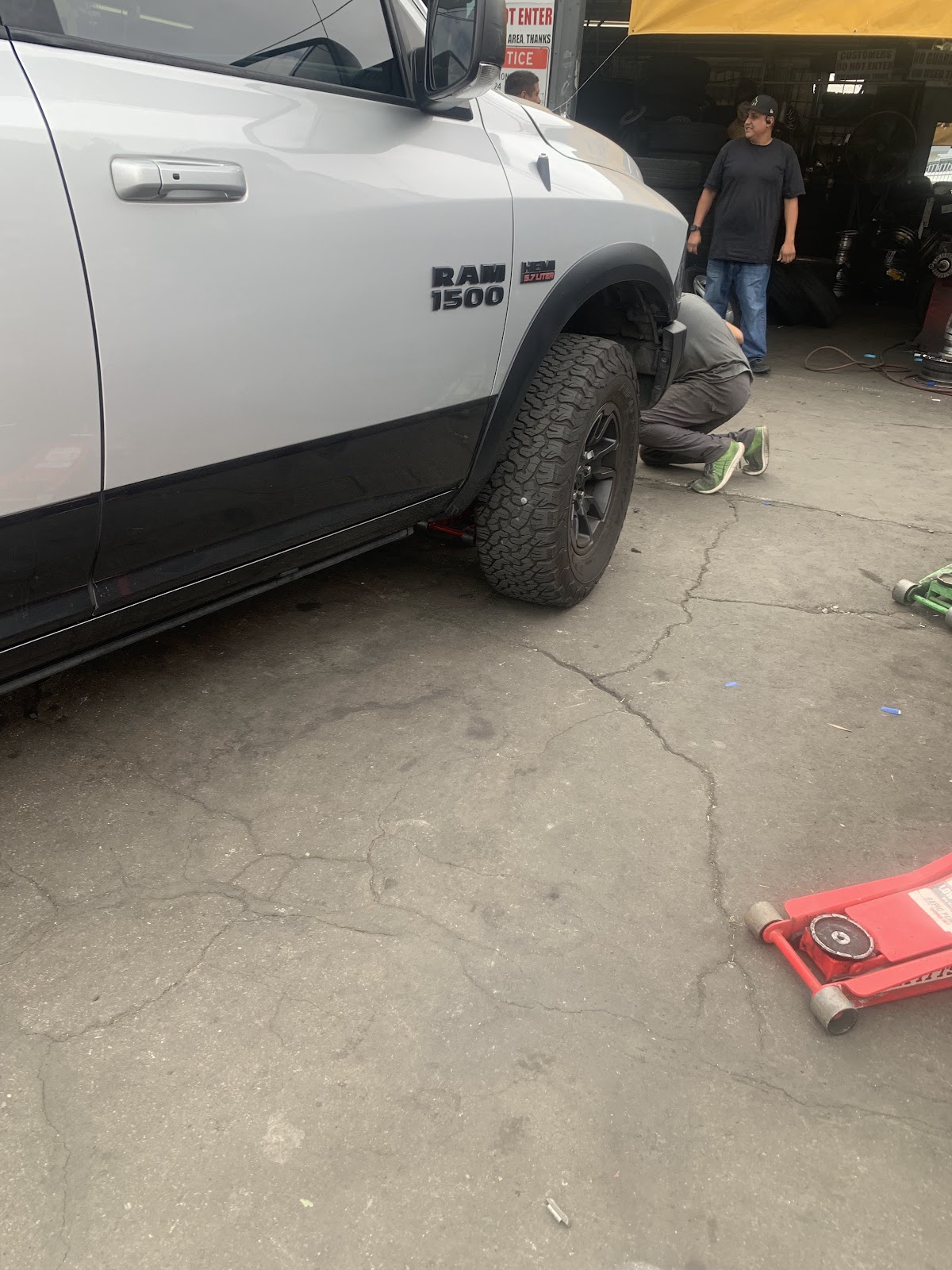 Technicians mounting a tire on a lifted RAM 1500 truck